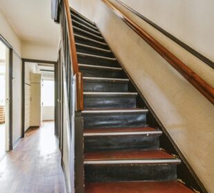 Wooden staircase in spacious hall of apartment Wooden staircase in spacious hall of apartment